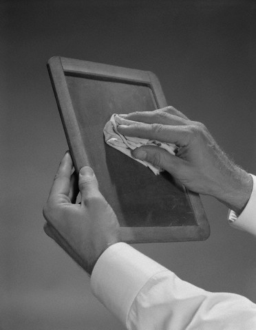 Male hands wiping slate clean